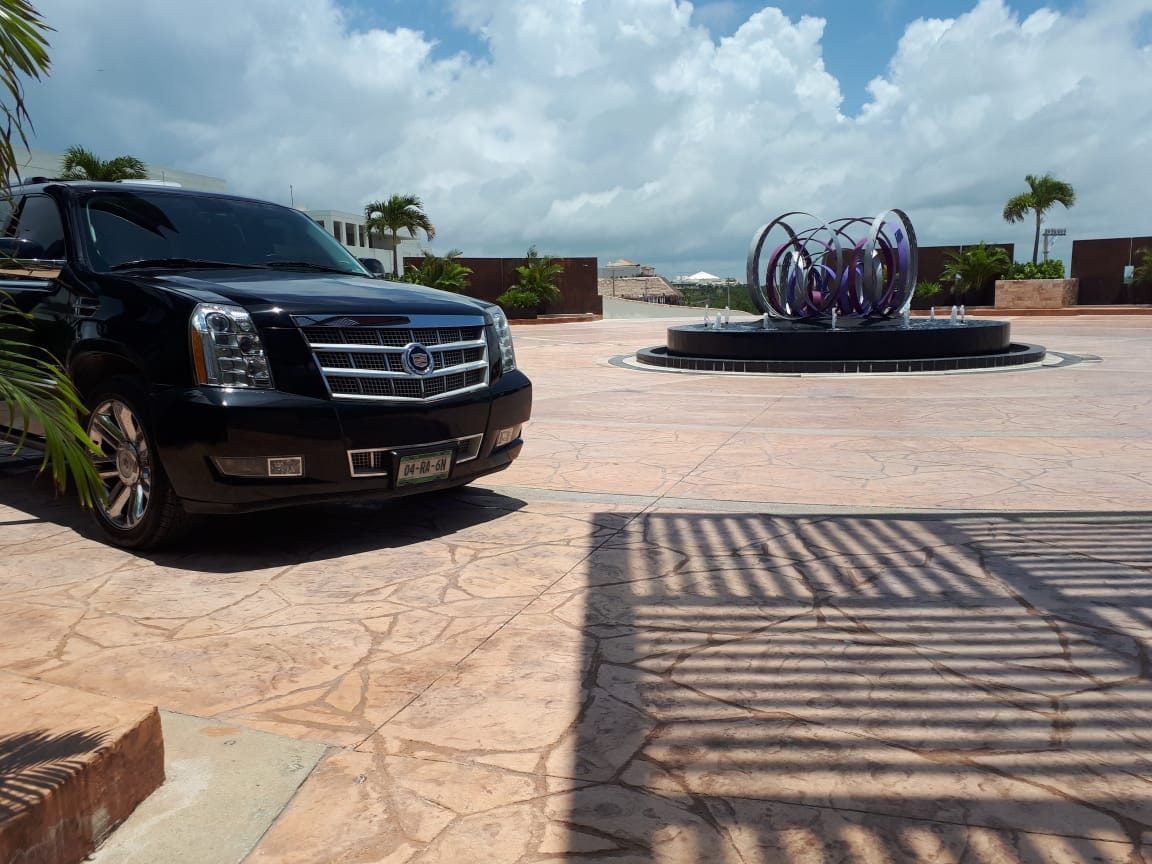 Black Luxury SUV in front of an art piece placed in hotel roundabout