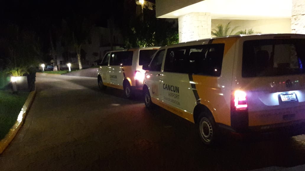 Two Private Transfer vans waiting for customers at hotel lobby by night 