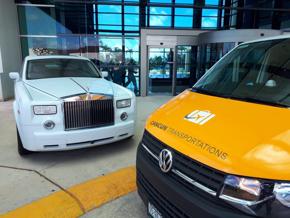 Van parked aside an exhibition vehicle outside hotel lobby
